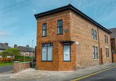 Brick building with black windows and door.