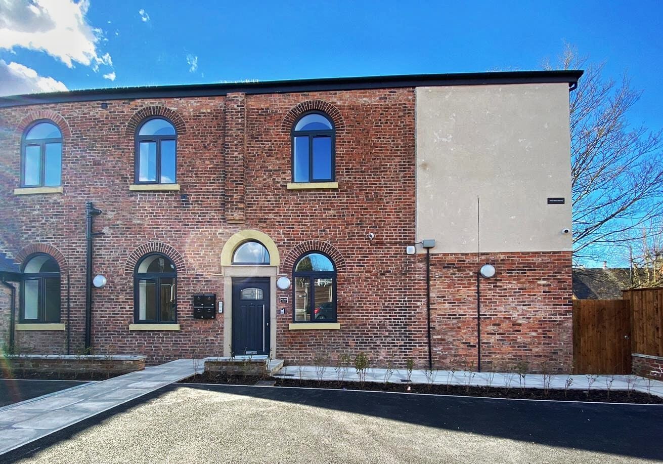 Brick building with arched windows and a door.